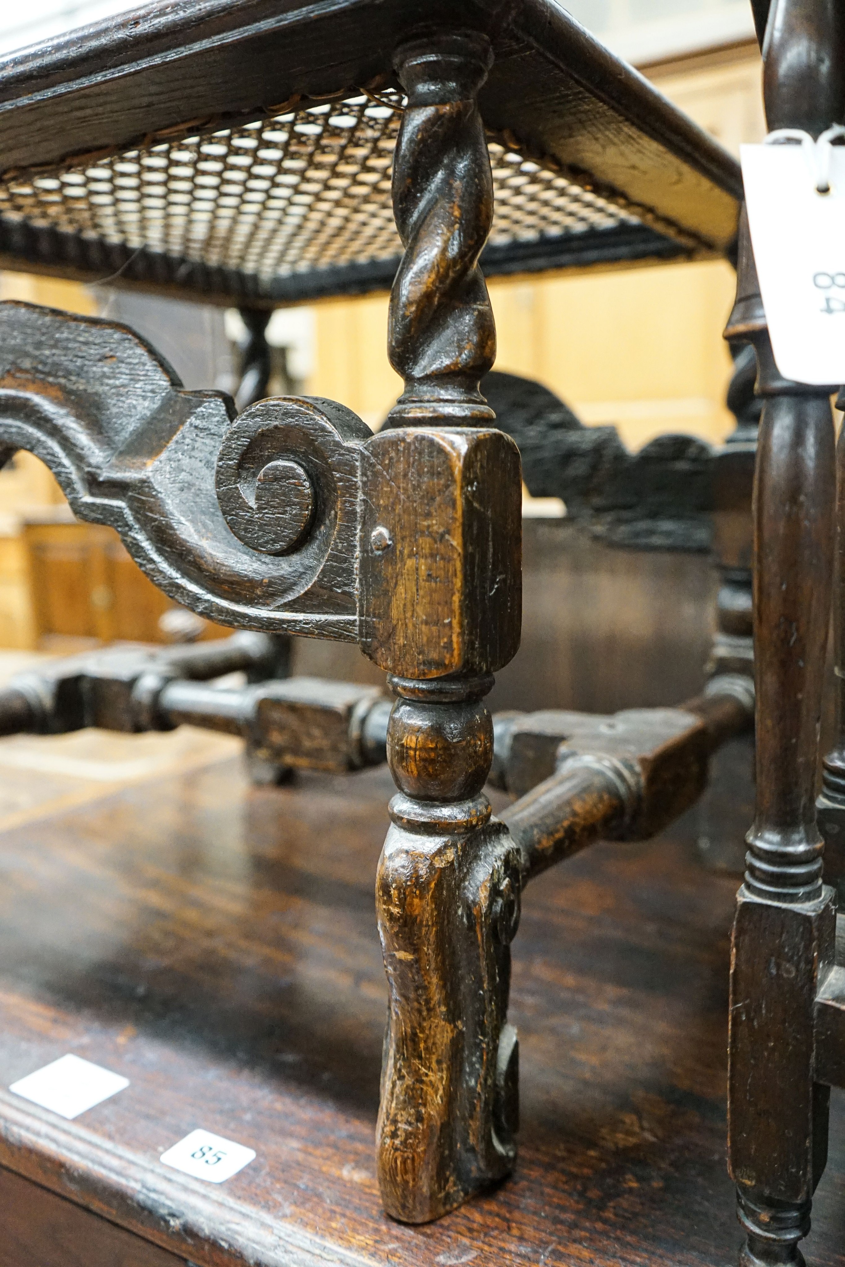 A 17th century style carved oak stool, with caned seat and H stretcher, width 47cm, depth 46cm, height 42cm